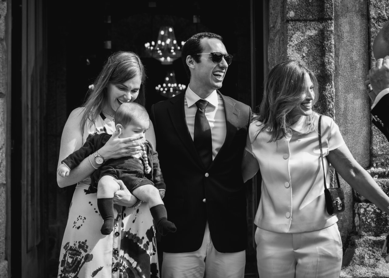 Fotografia de grupo do baptismo com família e padrinhos sorridentes